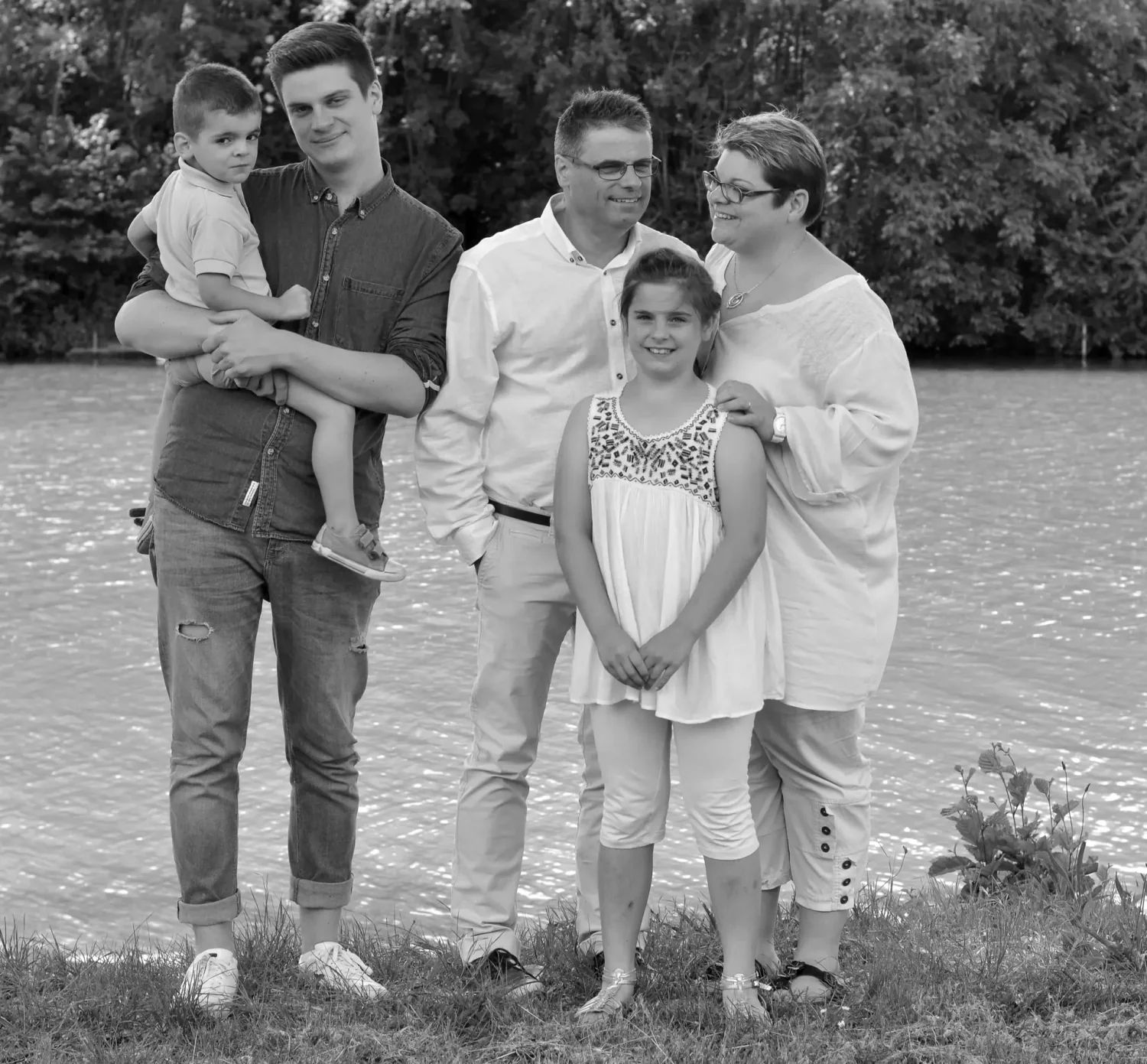 Famille de cinq au bord d'un étang, photo de groupe en noir et blanc