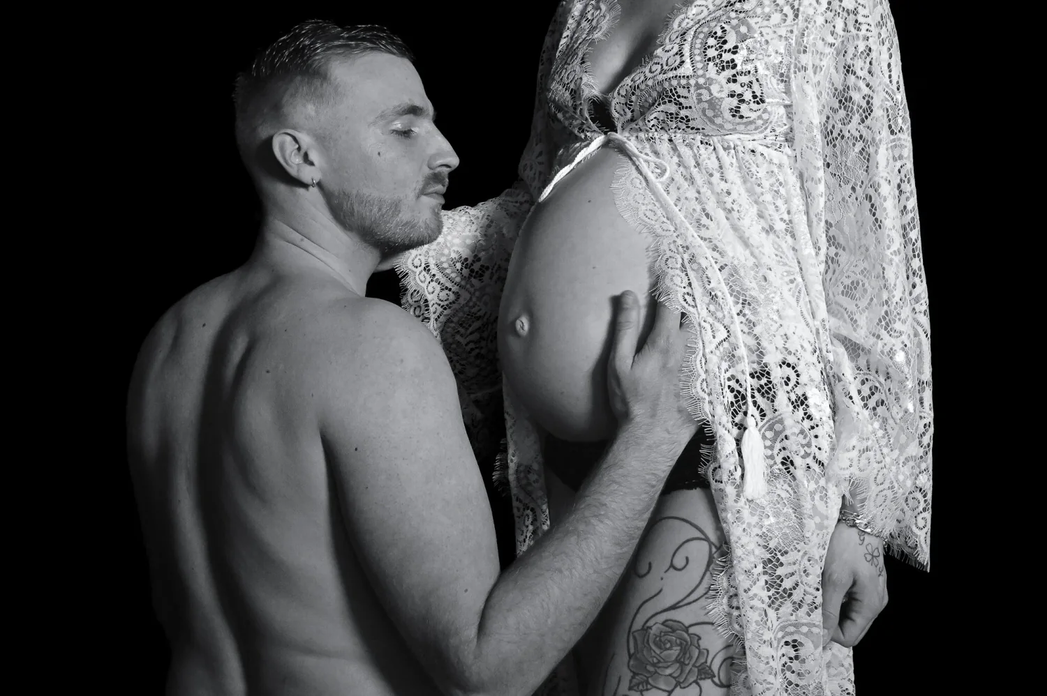 Couple enlacé, future maman en dentelle, séance grossesse en noir et blanc