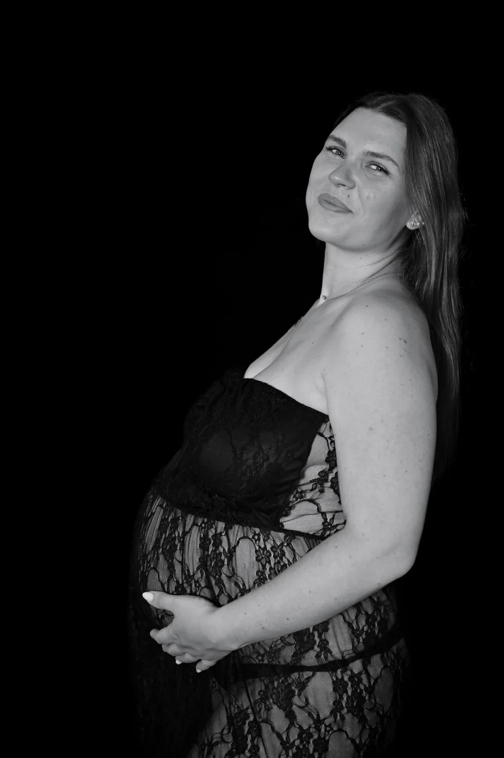 Portrait de future maman tenant son ventre, photo de grossesse en noir et blanc