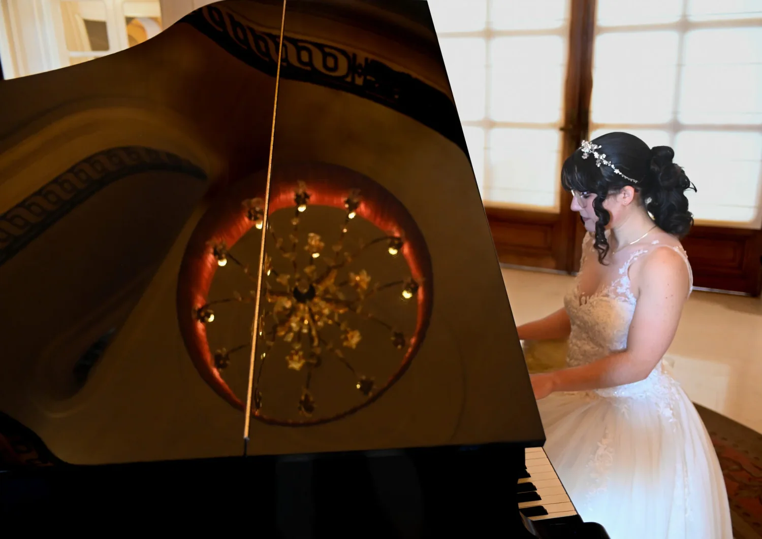 Mariée assise au piano dans une lumière chaude