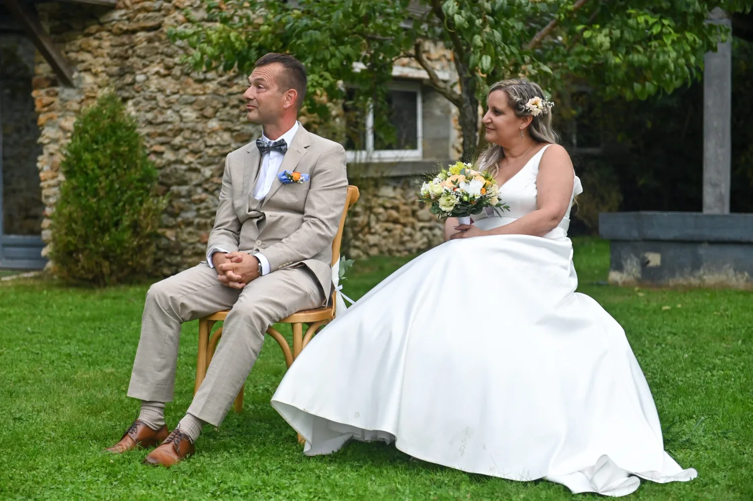 Mariés assis dans un jardin, reportage de mariage en extérieur