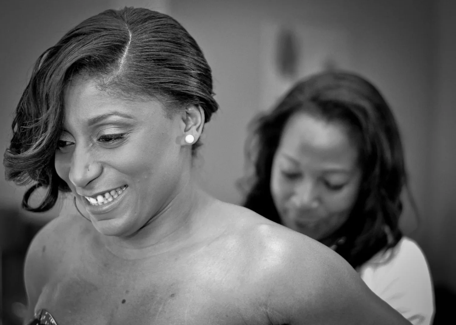 Mariée souriante pendant les préparatifs, photo en noir et blanc