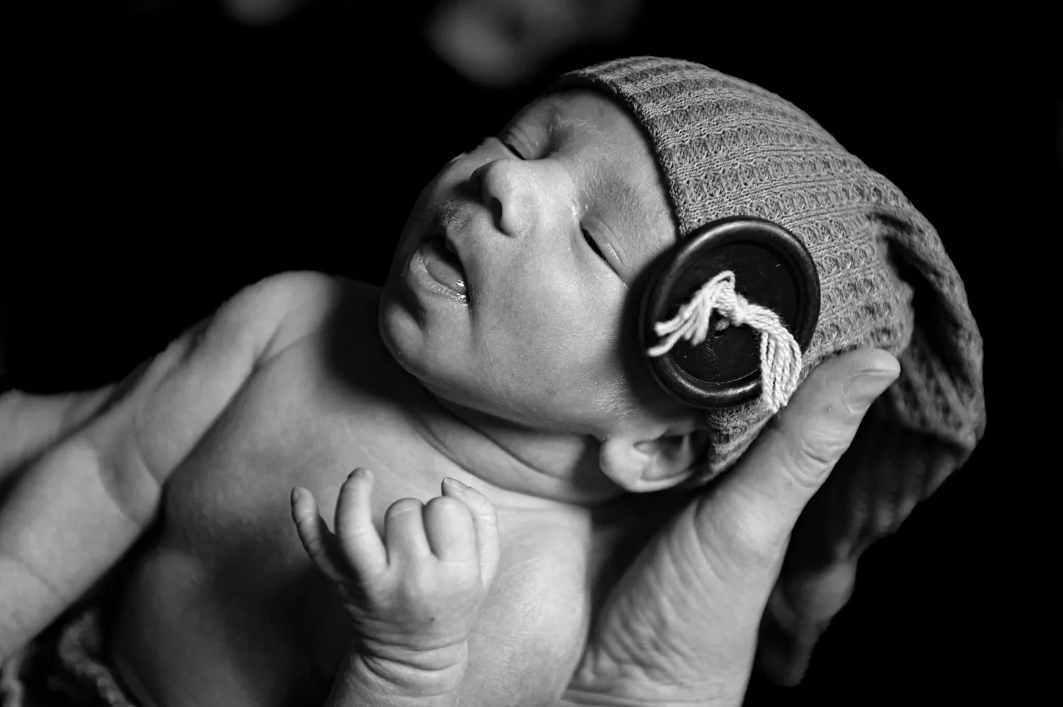 Nouveau-né avec bonnet et petit casque audio, en noir et blanc