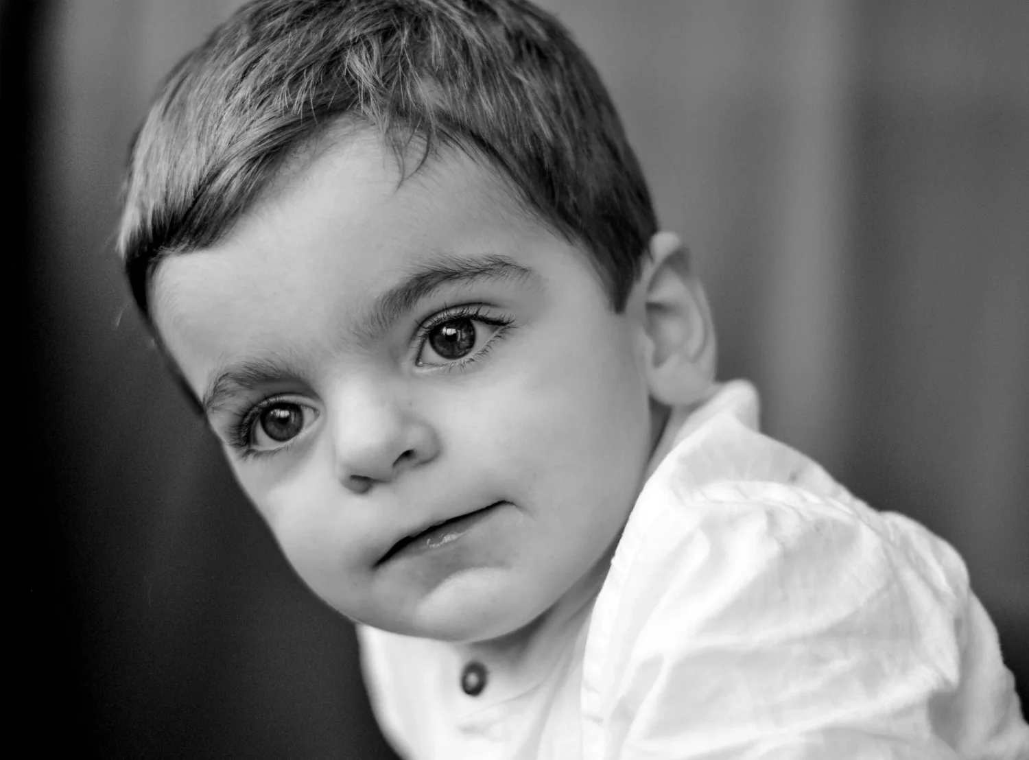 Portrait d'un petit garçon au regard pensif, en noir et blanc