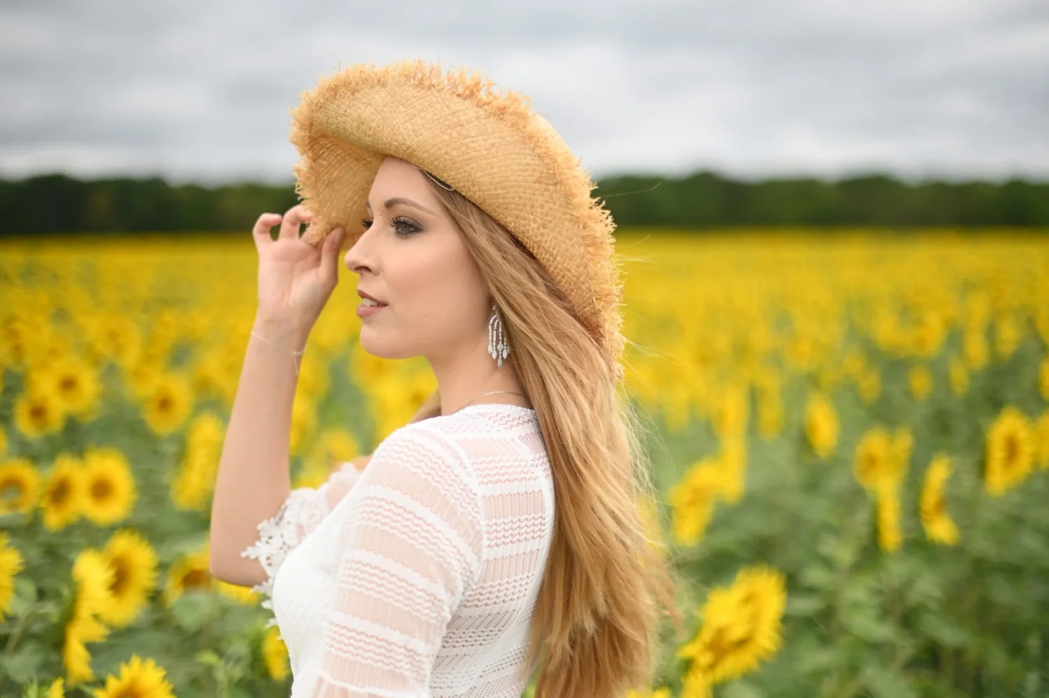 Portrait de femme avec un chapeau de paille dans un champ de tournesols