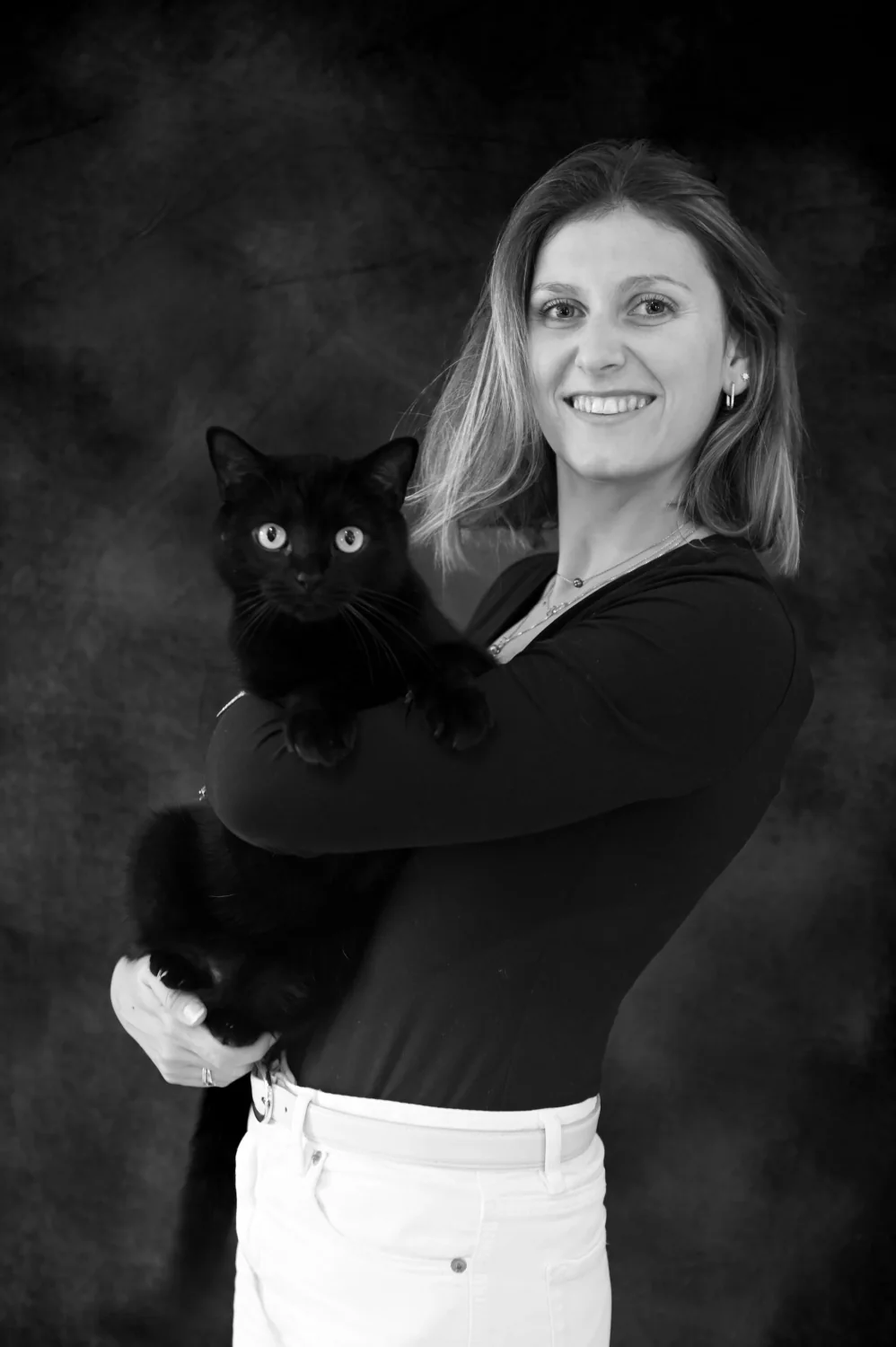 Portrait de femme tenant un chat noir, en noir et blanc