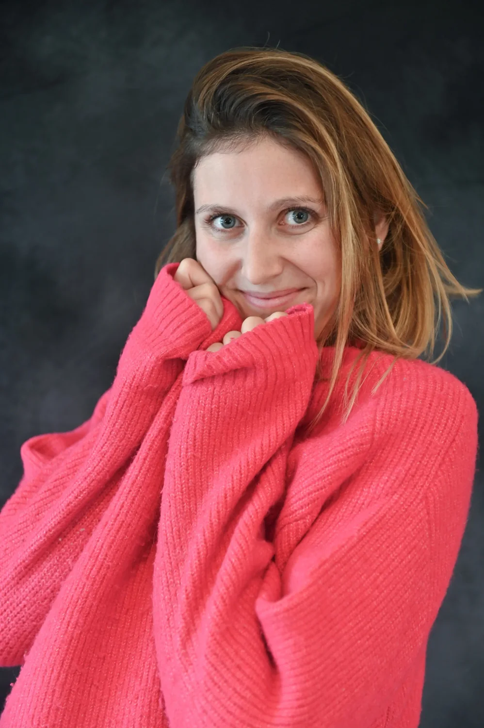 Portrait de femme souriante dans un pull rose