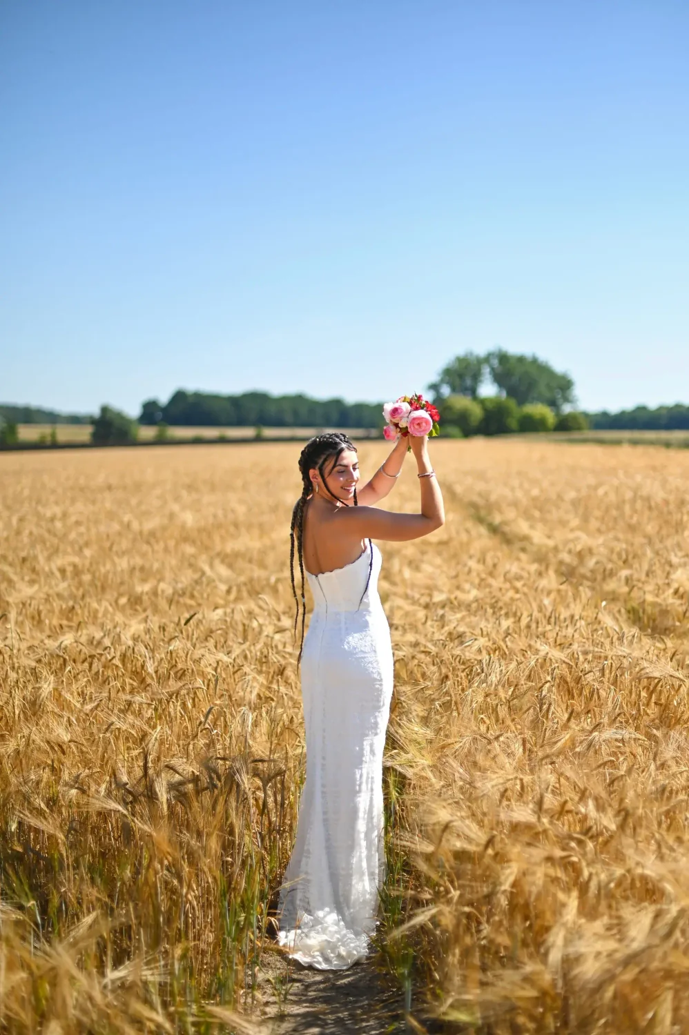 Portrait de femme en robe blanche dans un champ de blé