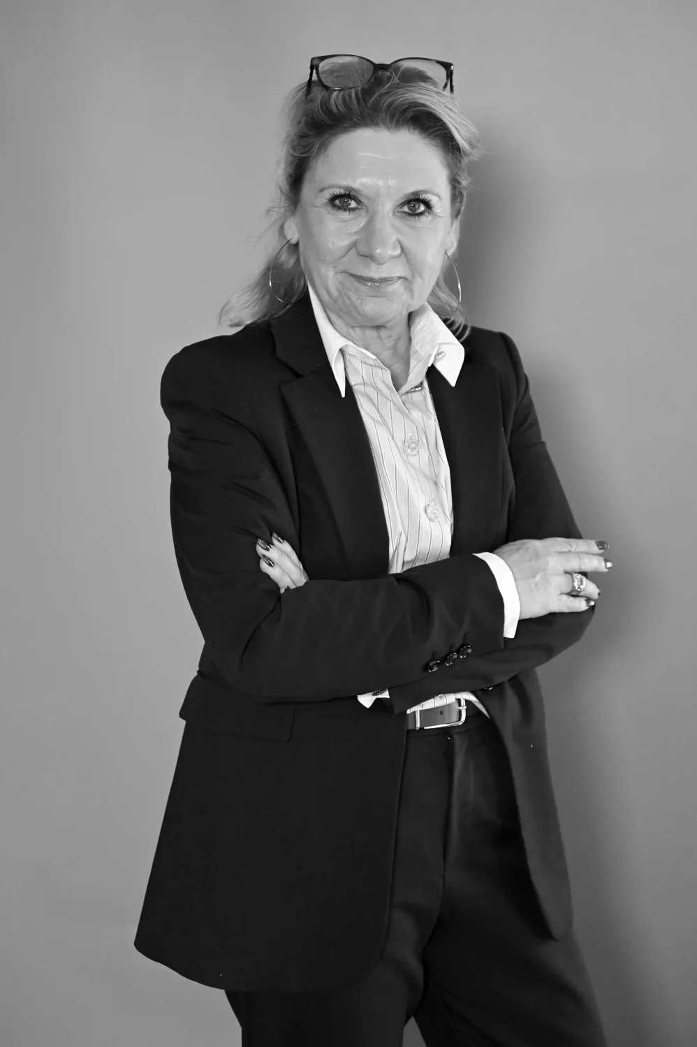Portrait professionnel d'une femme en tailleur noir, bras croisés