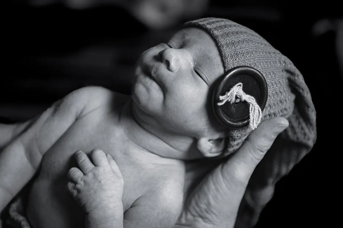 Nouveau-né avec bonnet pendant une séance photo naissance
