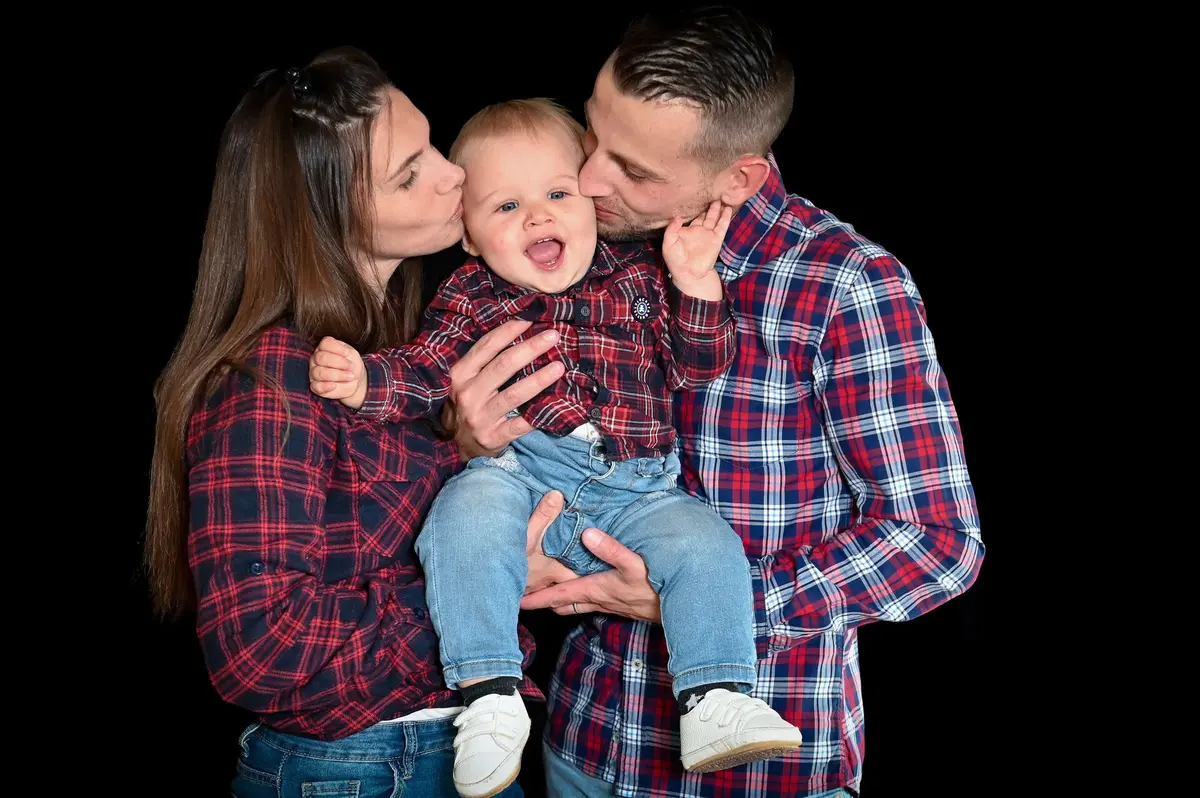 Parents embrassant leur bébé lors d’une séance photo famille