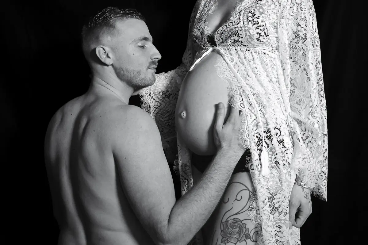 Couple enlacé pendant une séance photo grossesse